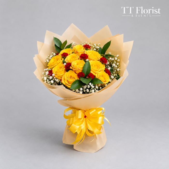 Bouquet of yellow roses with red accents wrapped in beige paper