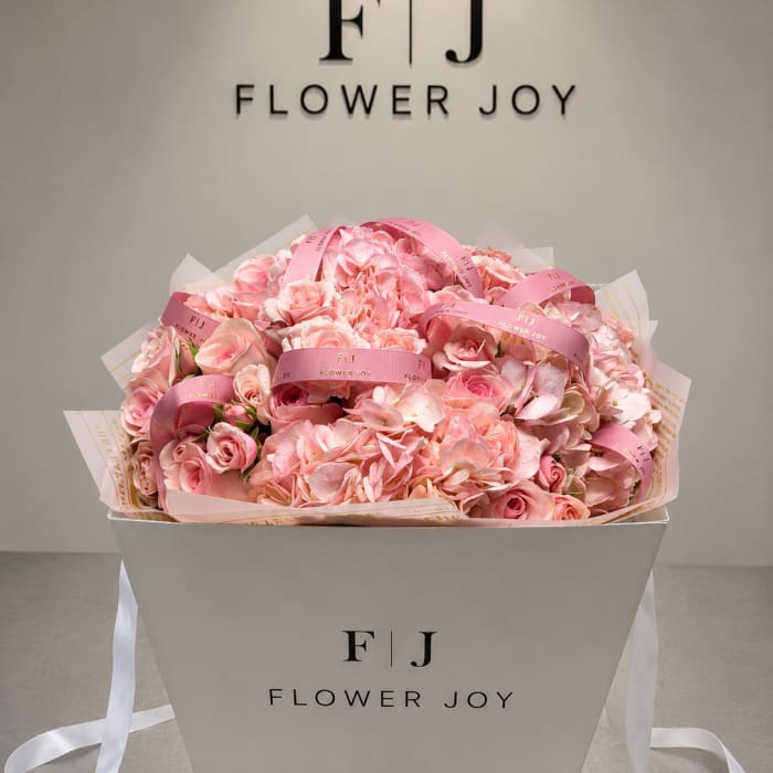 Pink rose and hydrangea bouquet in a white gift box with ribbon