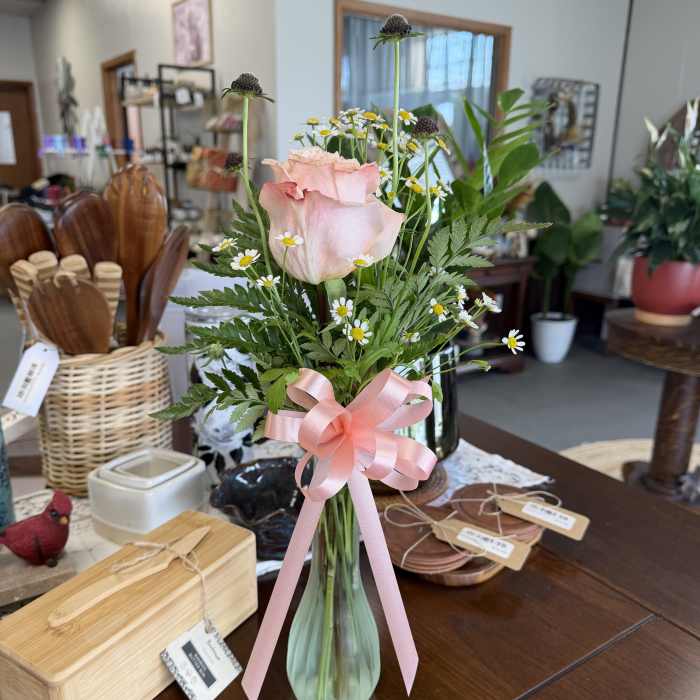 Pink rose arrangement in a glass vase with a ribbon bow