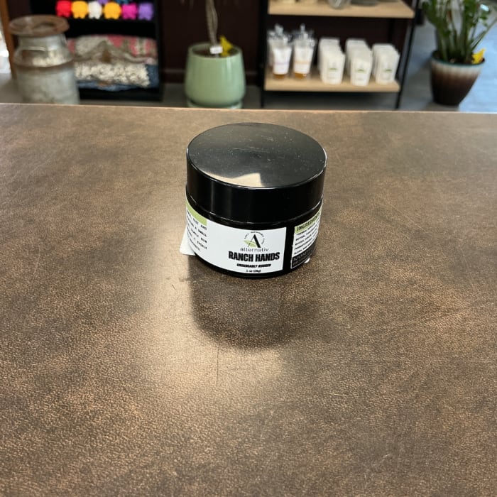Black-lidded jar of ranch hand cream on a counter