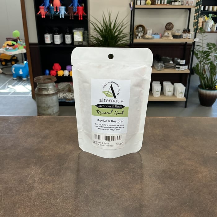 White pouch of lavender and rose mineral soak on a counter