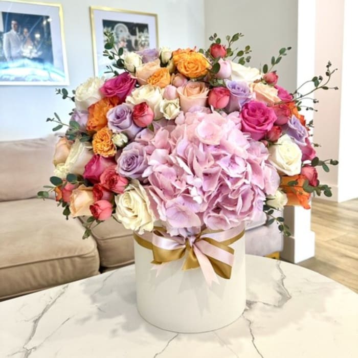Mixed roses and hydrangeas in a white hatbox with a ribbon