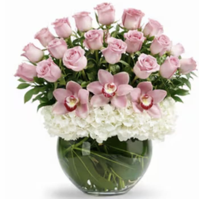 Pink roses and orchids arranged in a glass vase with white hydrangeas