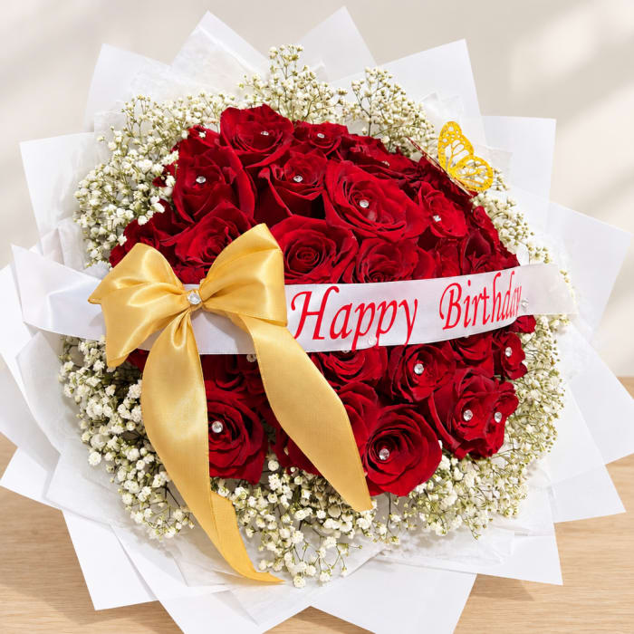 Red rose bouquet with baby's breath, a gold bow, and a Happy Birthday ribbon
