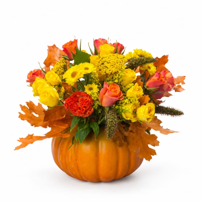 Autumn bouquet in a pumpkin container with yellow and orange flowers
