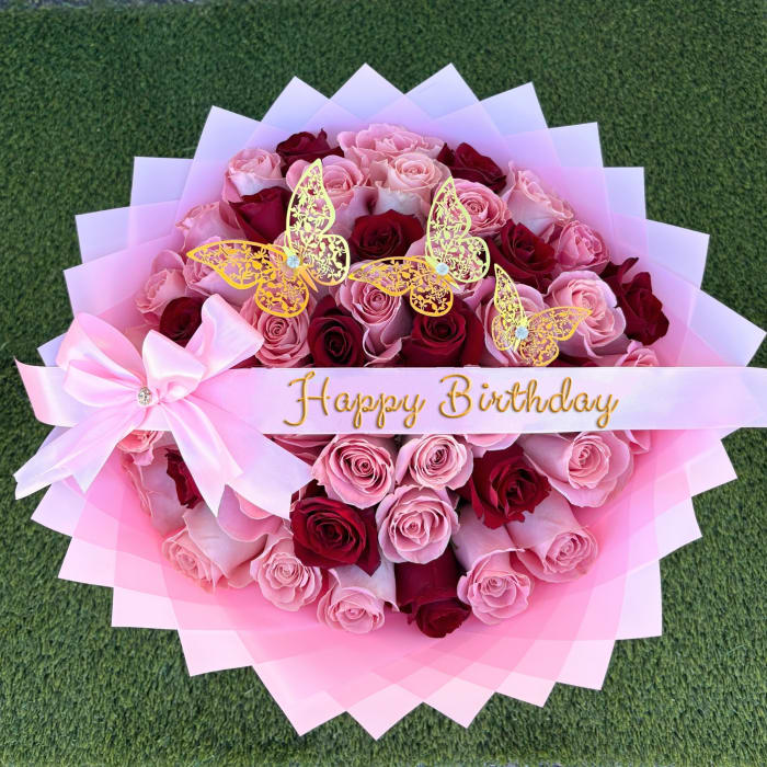 Pink and red rose bouquet with butterfly decorations and a Happy Birthday ribbon