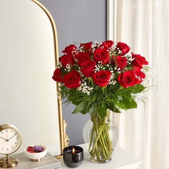 Bouquet of red roses in a clear glass vase with baby's breath