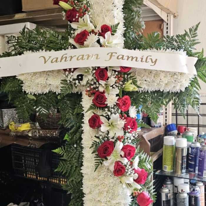 Large floral cross with red roses, white lilies, and white chrysanthemums