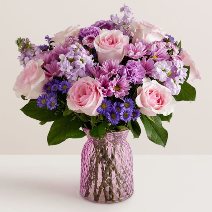 Pink and purple mixed bouquet in a pink glass vase