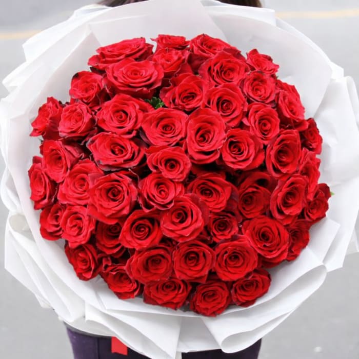 Large bouquet of red roses wrapped in white paper