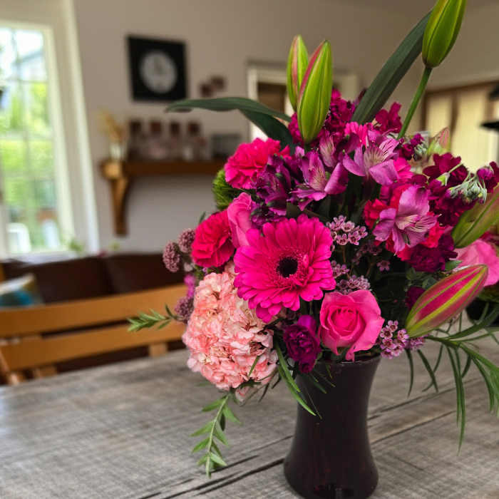 Pink and magenta mixed bouquet in a dark vase