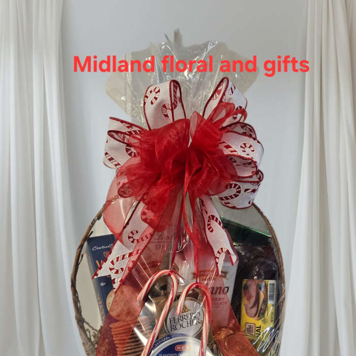 Gift basket with assorted snacks and candy, topped with a red ribbon bow