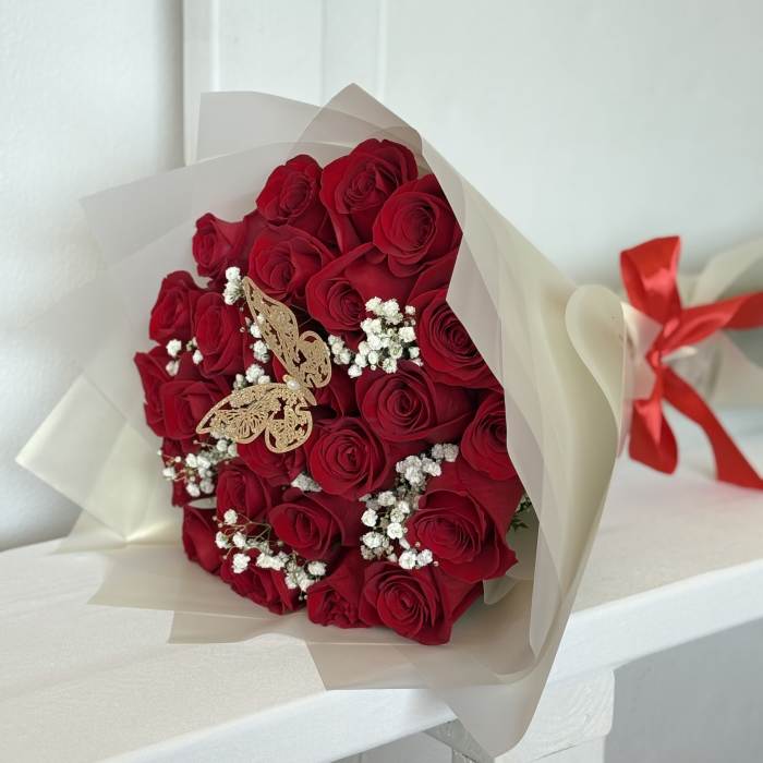 Bouquet of red roses with baby's breath in cream wrapping