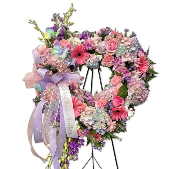 Pastel floral standing wreath on an easel with lavender ribbons