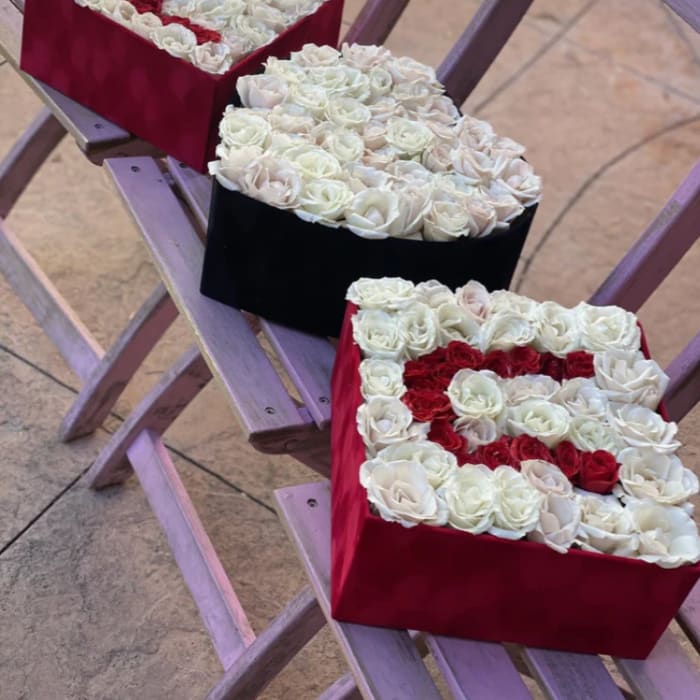Three heart-shaped rose boxes in red, black, and red