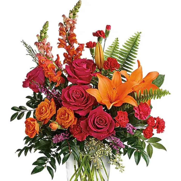 Bouquet of orange lilies and pink roses in a clear glass vase