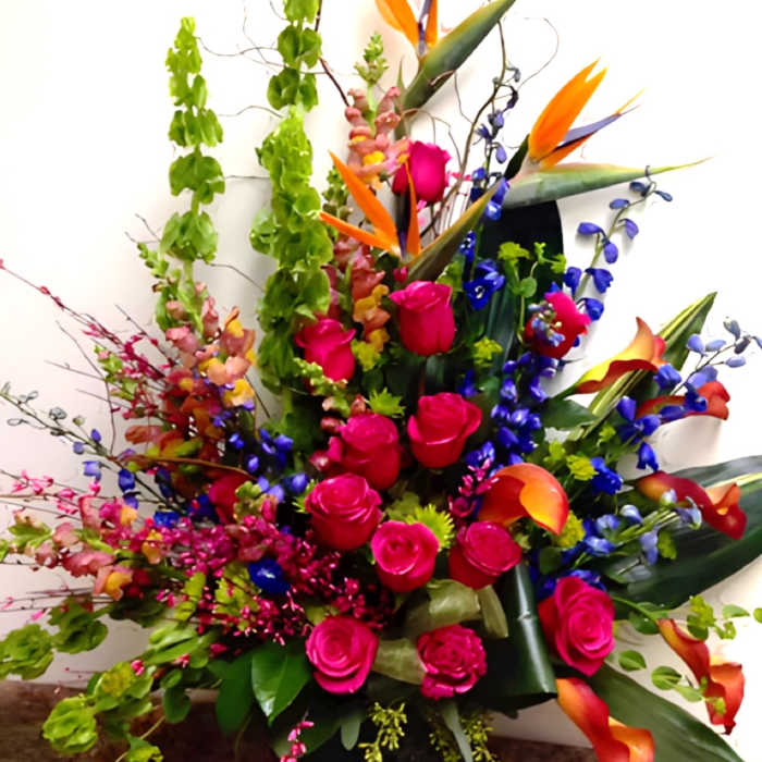 Bright tropical bouquet with pink roses and orange bird-of-paradise flowers
