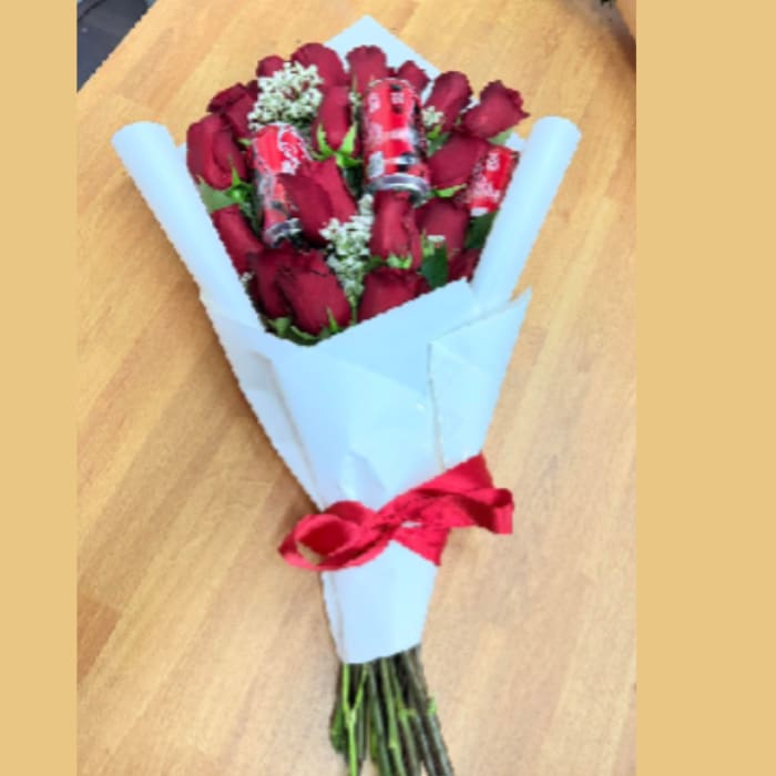 Bouquet of red roses wrapped in white paper with a red ribbon