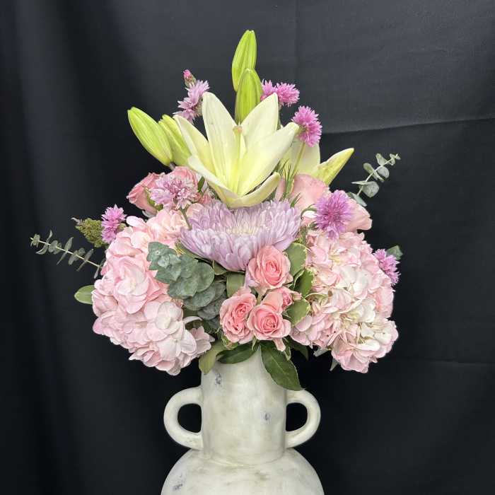 Pink and white floral arrangement in a white vase