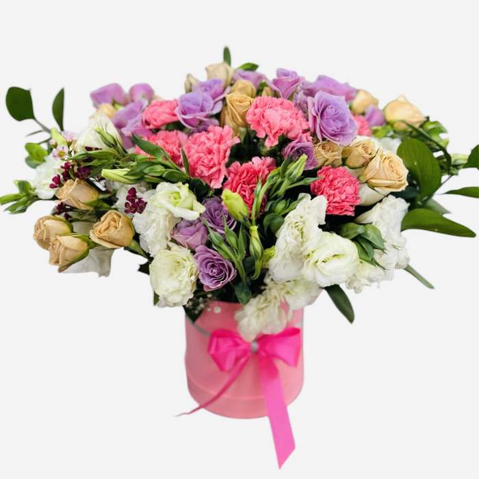 Bouquet of pink, purple, and cream flowers in a pink box with ribbon