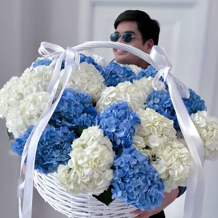 Large basket of blue and white hydrangeas with white ribbons