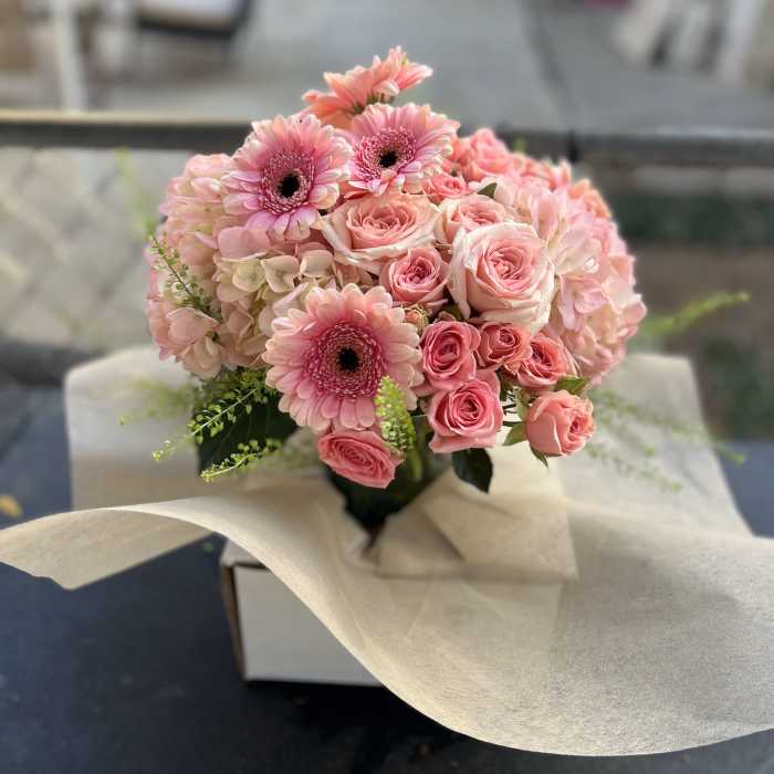Pink roses and gerbera daisies in a wrapped bouquet