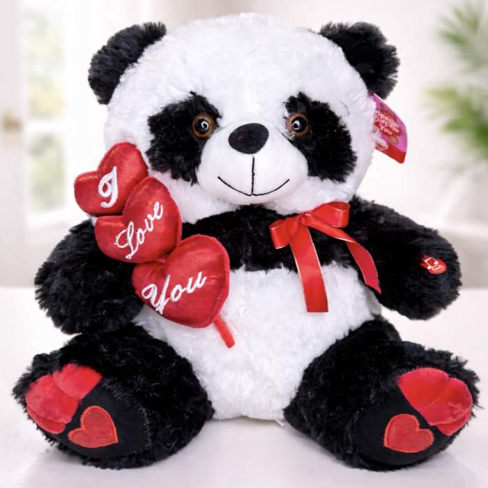 Plush panda bear holding red heart decorations and a ribbon