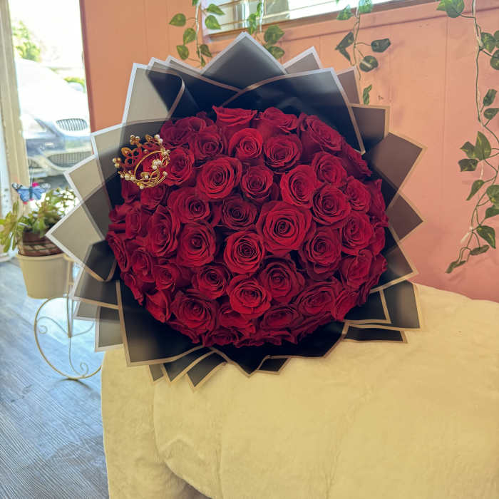 Large bouquet of red roses wrapped in black paper