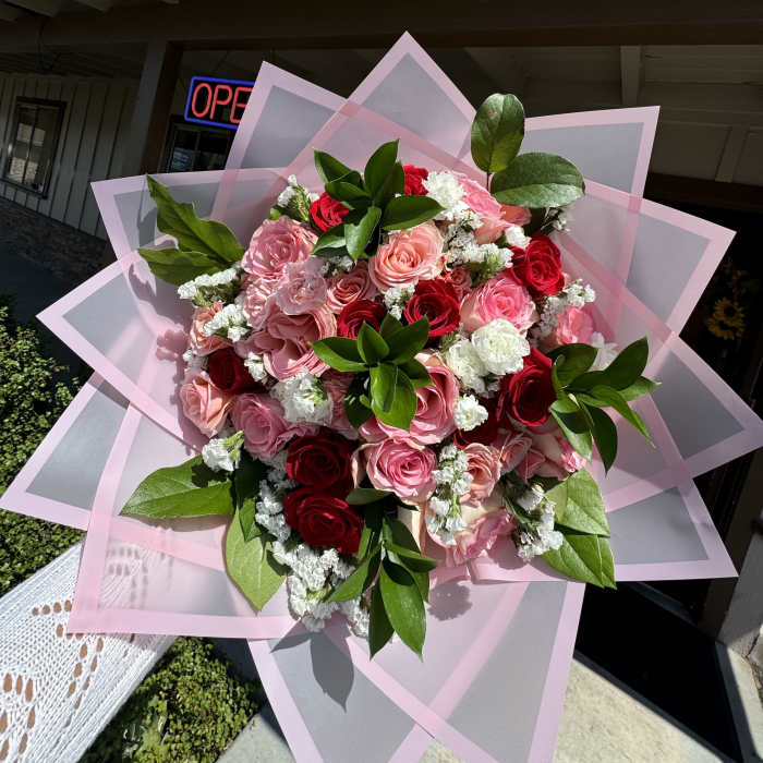 Bouquet of pink and red roses wrapped in pink paper