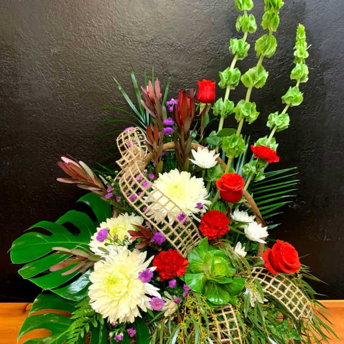 Mixed floral arrangement with red roses, white chrysanthemums, and tall green spikes