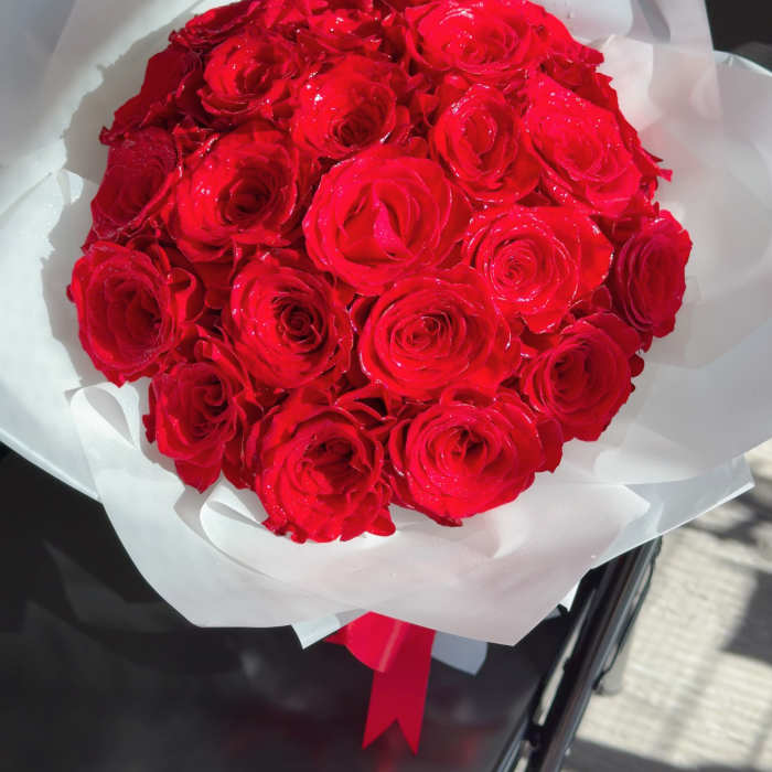 Bouquet of red roses wrapped in white paper