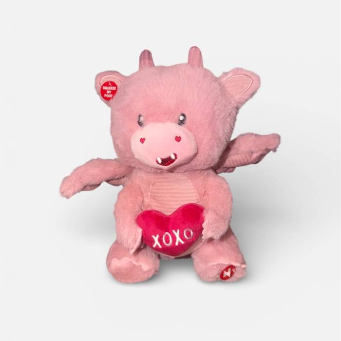 Pink plush pig holding a heart with "XOXO"