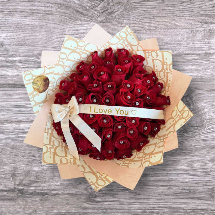 Bouquet of red roses wrapped in patterned paper with a ribbon