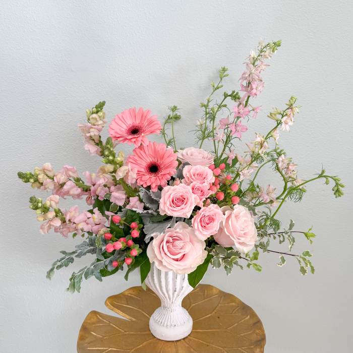 Pink roses and gerbera daisies in a white vase