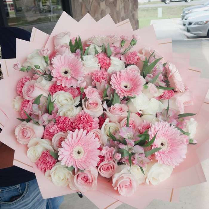 Pink and white bouquet with gerbera daisies and roses in pale pink wrap