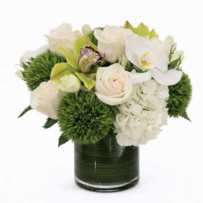 White and pale green floral arrangement in a glass vase