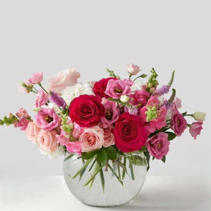 Pink and red mixed flower arrangement in a clear glass vase