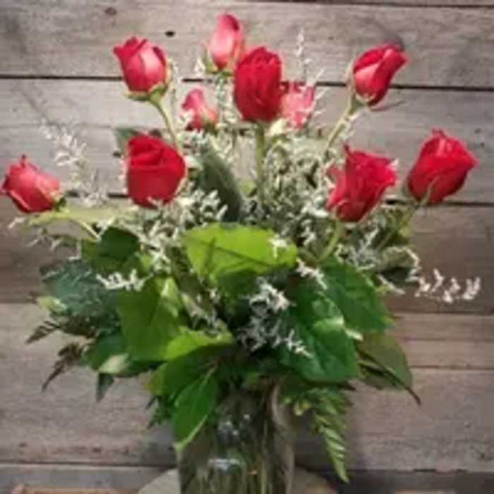 Red roses arranged in a clear glass vase