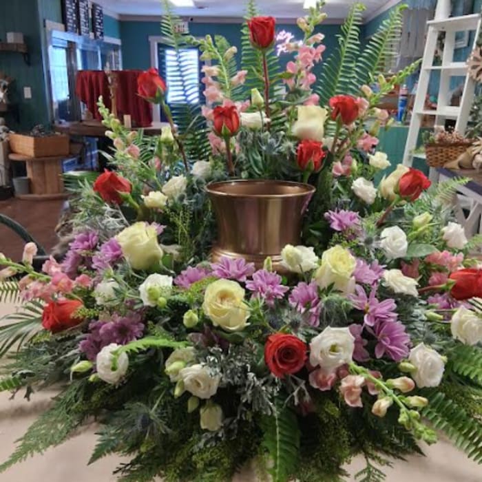 Large floral centerpiece with red and white roses around a gold vase