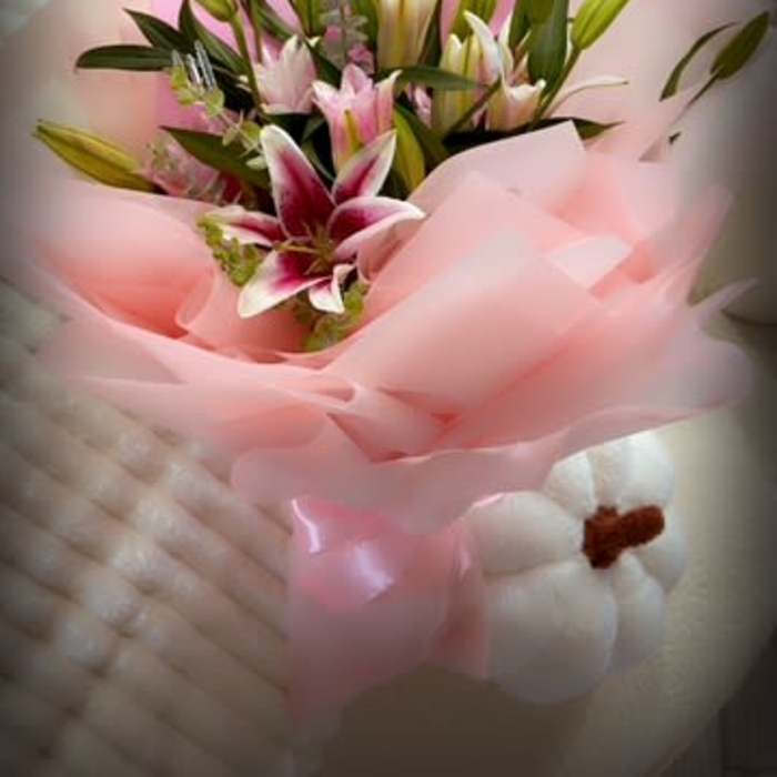 Bouquet of pink and white lilies wrapped in pink paper