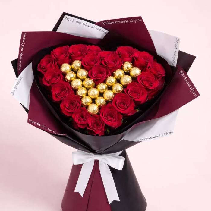 Heart-shaped bouquet of red roses with gold chocolates in decorative wrap