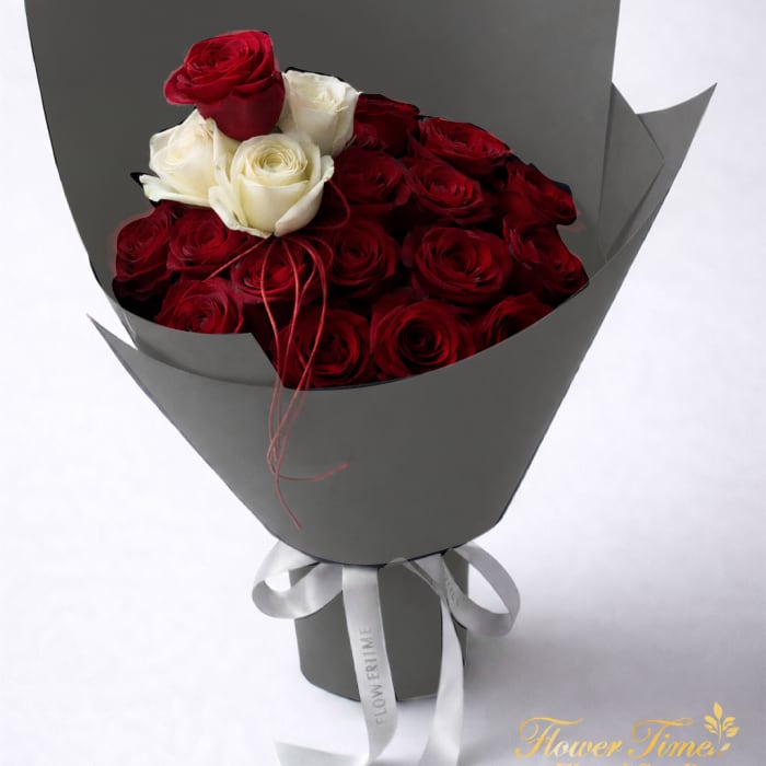 Bouquet of red and white roses wrapped in gray paper