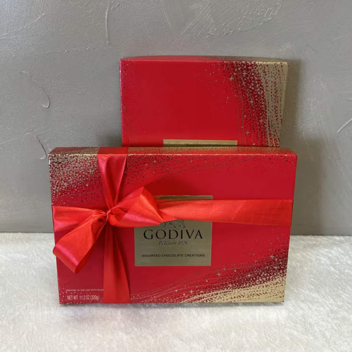 Two red Godiva chocolate gift boxes with a satin ribbon