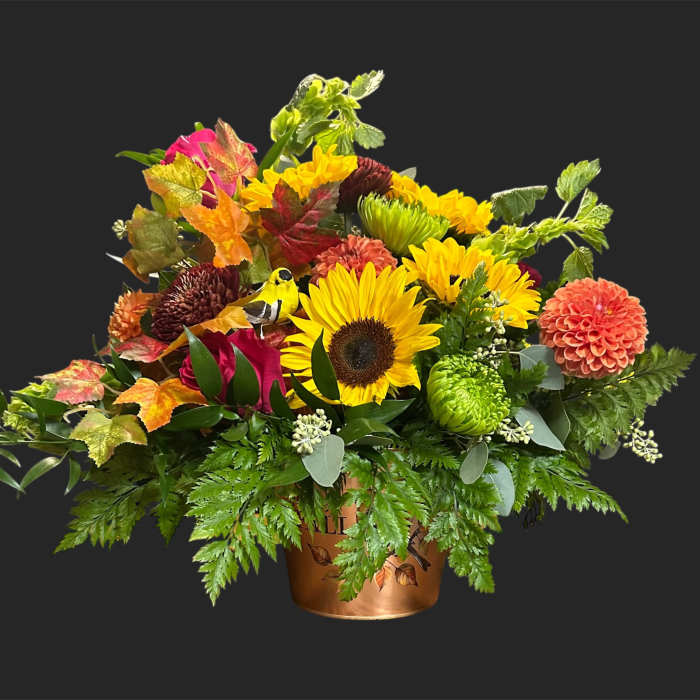 Mixed autumn bouquet with sunflowers and dahlias in a copper container