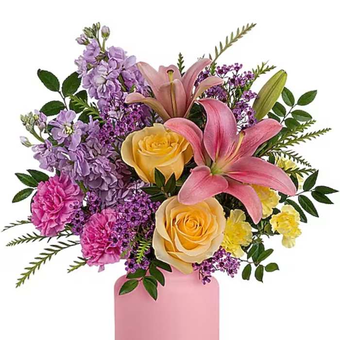 Bouquet of pink lilies, yellow roses, and purple flowers in a pink vase