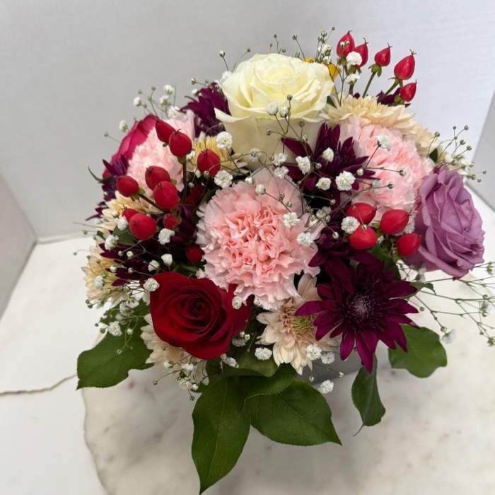 Mixed bouquet with roses, carnations, and purple blooms