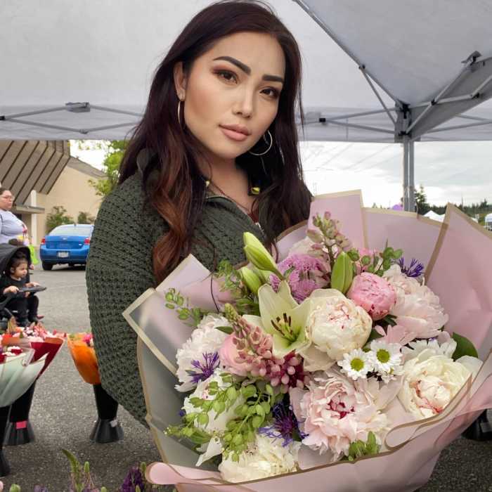Woman holding a large bouquet of pink and white flowers