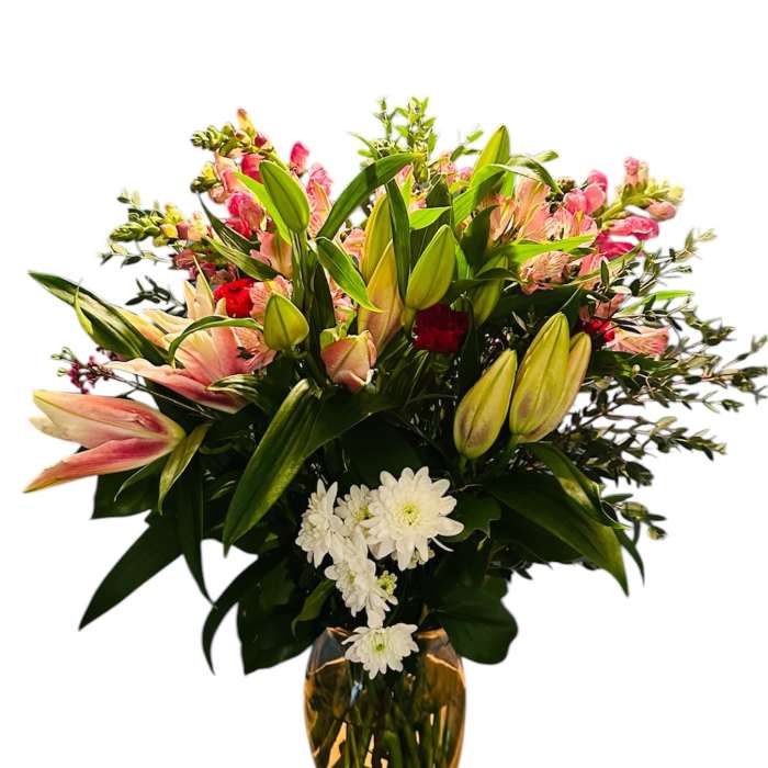 Bouquet of pink lilies, red flowers, and white daisies in a glass vase
