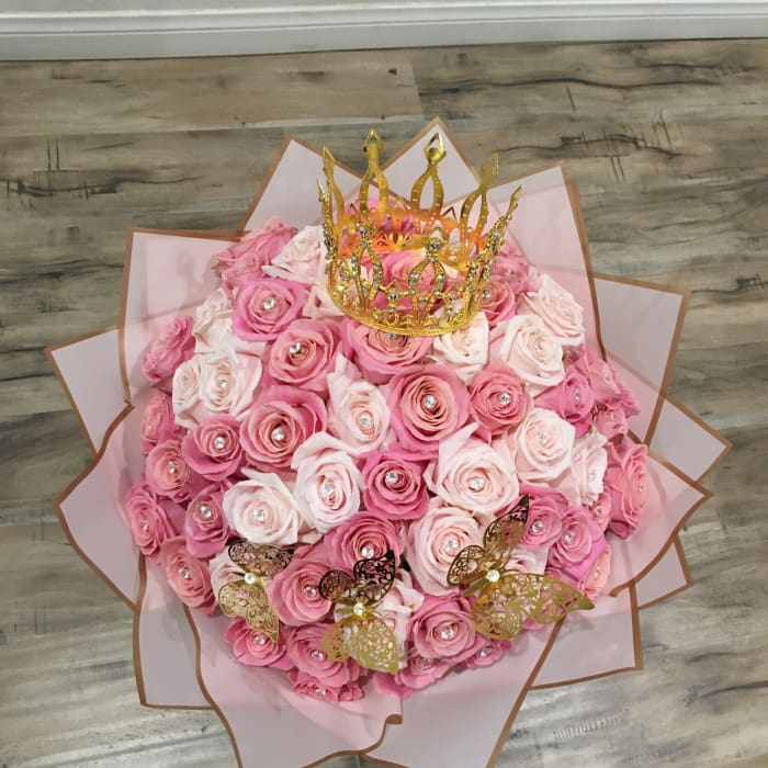 Pink rose bouquet with a gold crown topper and butterfly accents
