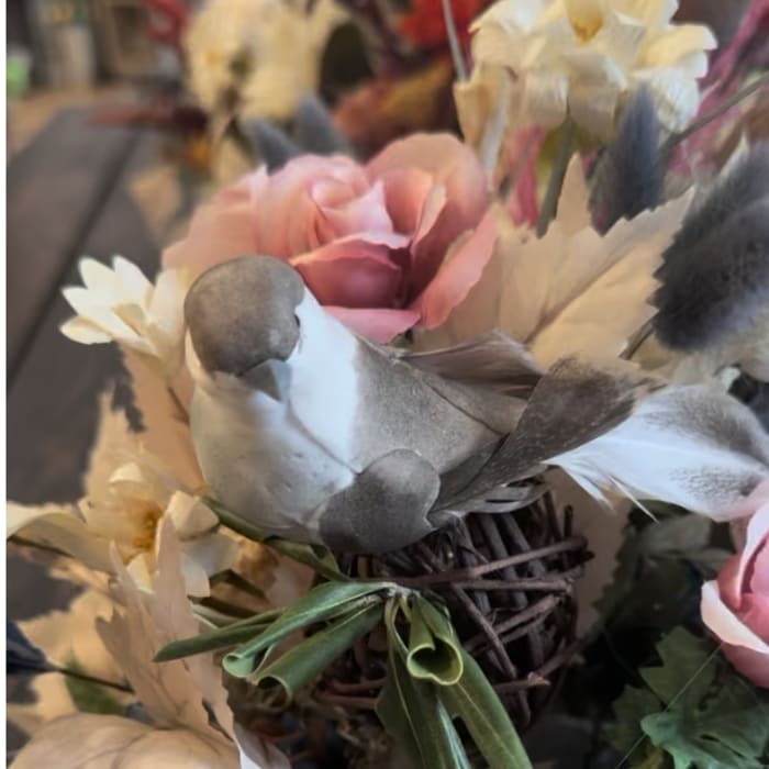 Pink and white floral arrangement with a woven bird nest centerpiece